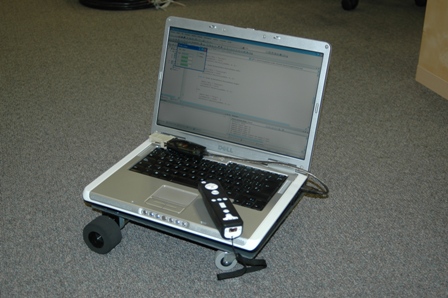 Foto del FlatBot con un PC y el mando de la Wii
